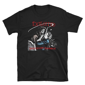 Pode incluir: Camiseta preta com um gráfico de um esqueleto segurando uma mulher. O texto "The Exploited" e "Death Before Dishonour" está impresso na camiseta.