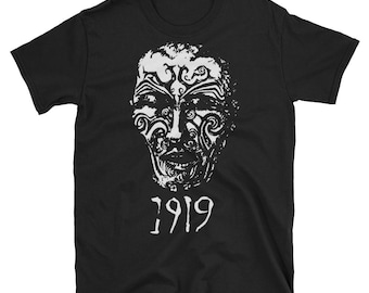 May include: Black t-shirt with a white graphic of a face with tribal markings and the year 1919 printed below.