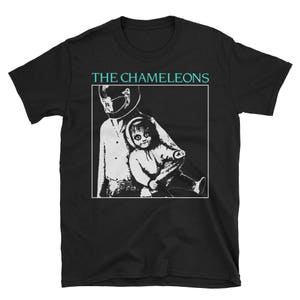 Puede incluir: Camiseta negra con un gráfico blanco de dos figuras. El texto "THE CHAMELEONS" está impreso en blanco sobre el gráfico.
