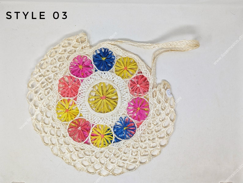 Pu&ograve; includere: Una borsa a rete intrecciata color bianco sporco con il testo STYLE 03 nell'angolo in alto a sinistra. Il centro della borsa &egrave; decorato con un motivo circolare di piccoli elementi floreali dai colori vivaci in rosa, giallo e blu.