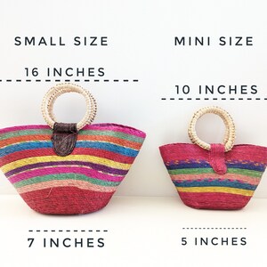 May include: Two woven straw handbags with horizontal stripes in red, pink, yellow, green, and blue. The small size measures 16 inches wide by 9 inches high with a 7-inch base. The mini size measures 10 inches wide by 6 inches high with a 5-inch base.