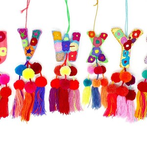 May include: A set of seven colourful felt letter ornaments with pom-poms and tassels. The letters are U, V, W, X, Y, and Z.