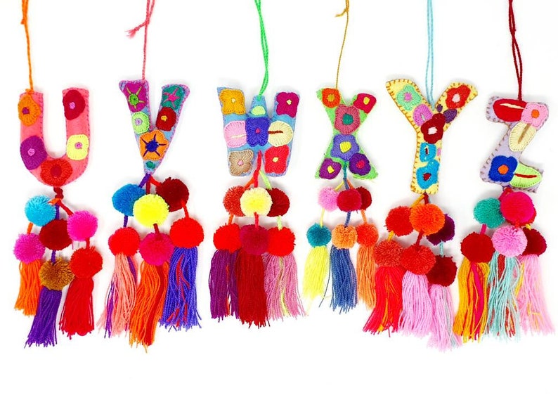 May include: A set of seven colourful felt letter ornaments with pom-poms and tassels. The letters are U, V, W, X, Y, and Z.