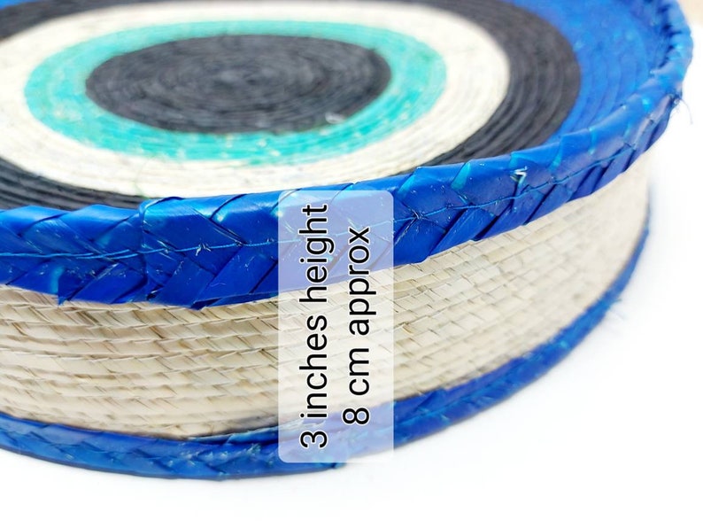 May include: A woven straw target with blue and black rings. The target is 3 inches high and 8 cm in diameter.