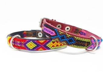 May include: Two colourful dog collars with geometric patterns. The collars are made of leather and have metal D-rings. The collars are red, green, blue, yellow, purple and pink.