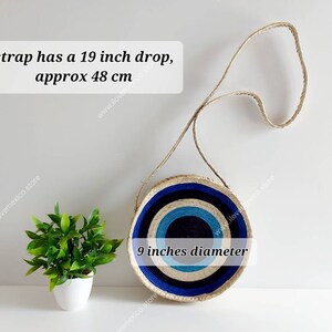 May include: A round straw bag with blue and white stripes. The bag has a 19 inch drop strap and is 9 inches in diameter. "strap has a 19 inch drop, approx 48 cm" and "9 inches diameter" are written on the bag.