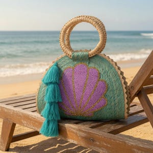 May include: A semi-circular woven straw handbag in a teal green hue, featuring a prominent purple seashell appliqué with gold beaded detailing. The bag includes two round woven straw handles and a long, layered teal green tassel fringe on the side.