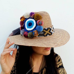 Mexican straw hat with eye and pompom decoration