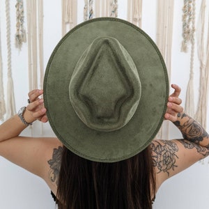 Puede incluir: Un sombrero fedora de fieltro verde con una hendidura en forma de diamante en la corona.