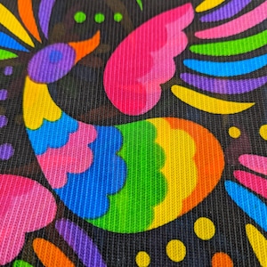 May include: A black mesh fabric featuring a vibrant, multi-colored bird graphic. The bird is composed of bright neon pink, blue, green, yellow, orange, and purple segments. Additional colorful abstract shapes and dots surround the bird design.