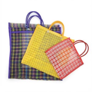 May include: Three square tote bags in descending sizes, each featuring a translucent plaid pattern. The largest bag is purple and blue, the medium bag is yellow, and the smallest bag is red. Each bag has two matching circular handles.