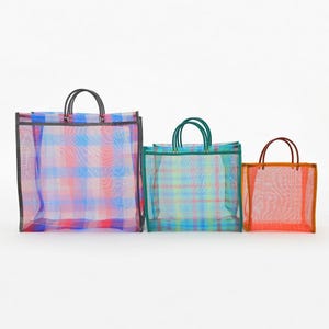 May include: Three rectangular tote bags made of semi-transparent mesh material in varying sizes. The largest bag features a blue and pink plaid pattern with black handles. The medium bag has a teal and yellow plaid pattern with teal handles.