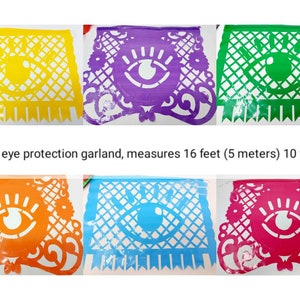 May include: A colorful paper garland with ten flags featuring an evil eye design. Each flag is a different color: yellow, purple, green, orange, blue, and pink. The garland measures 16 feet (5 meters) long.