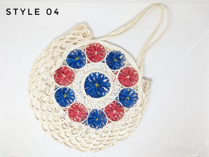 Pu&ograve; includere: Una borsa tote rotonda intrecciata color bianco sporco con due manici, che riporta il testo STYLE 04 nell'angolo in alto a sinistra. Il centro &egrave; decorato con un motivo circolare di fiori intrecciati alternati rossi e blu.