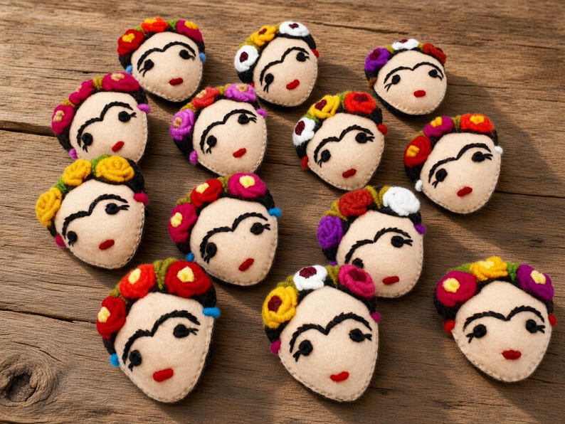 May include: A collection of twelve felt appliques, each shaped like a face with embroidered features including thick eyebrows, dark eyes, and red lips. Each face is adorned with a crown of small, colorful felt flowers in red, yellow, and purple.