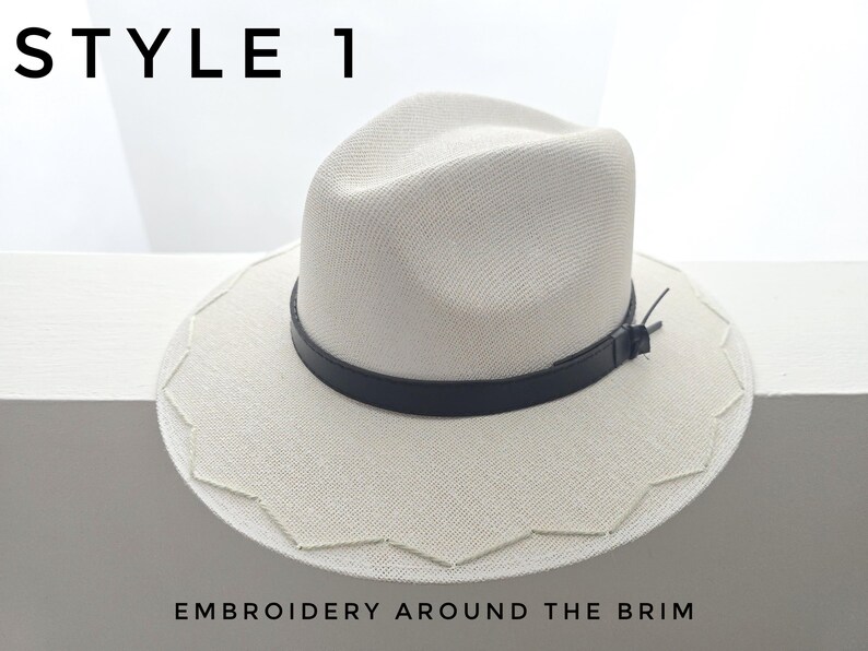 May include: A cream-colored fedora hat featuring a black leather band around the crown and a scalloped edge with embroidery around the brim. The text STYLE 1 and EMBROIDERY AROUND THE BRIM are visible in the image.