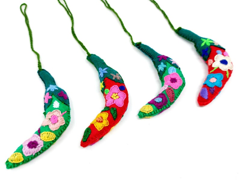 May include: Four handmade felt chili pepper decorations with colourful embroidered flowers. Each ornament has a green stem and a loop for hanging.
