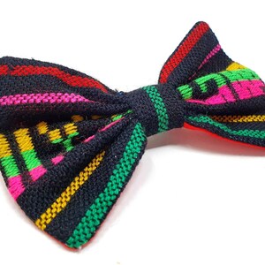 May include: A black bow tie with colorful stripes in red, pink, green, and yellow.