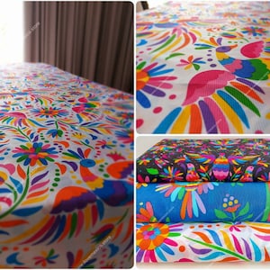 May include: A collection of fabric featuring vibrant, multi-colored patterns of birds and flowers. The designs are printed on white, blue, and black backgrounds, showcasing intricate, repeating motifs in bright shades of pink, yellow, and green.
