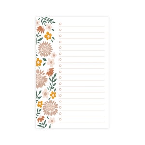 May include: A white notepad with a floral border. The border features a variety of flowers in shades of orange, yellow, pink, and green. The notepad has a lined interior with a dotted border and a circle for checking off tasks.