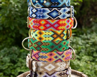 May include: A stack of colorful, woven dog collars with geometric patterns. The collars are made of a thick, durable material and feature a variety of colors, including blue, red, green, yellow, and brown.