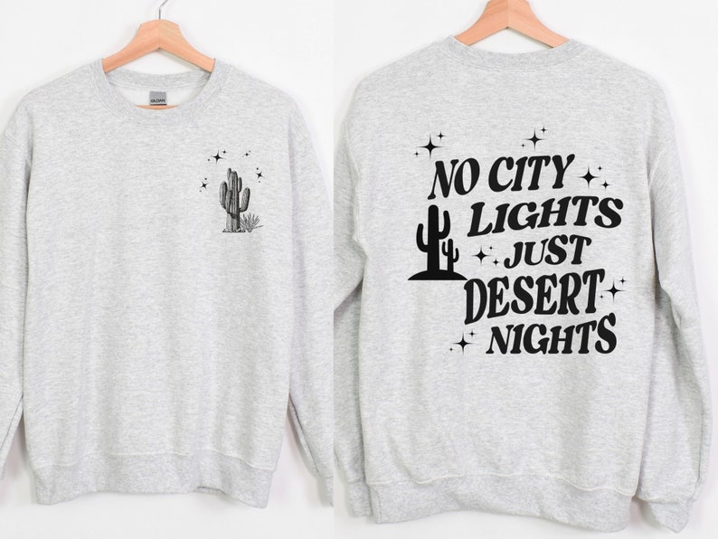 Może przedstawiać: Szara bluza z nadrukiem kaktusa i gwiazd na przodzie i napisem "NO CITY LIGHTS JUST DESERT NIGHTS" na plecach.