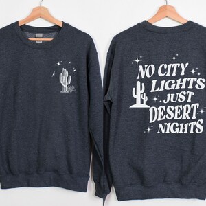 Może przedstawiać: Szara bluza z nadrukiem białego kaktusa z przodu i napisem "NO CITY LIGHTS JUST DESERT NIGHTS" z tyłu.