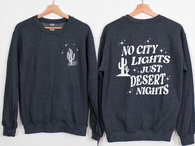 Może przedstawiać: Szara bluza z nadrukiem białego kaktusa z przodu i napisem "NO CITY LIGHTS JUST DESERT NIGHTS" z tyłu.