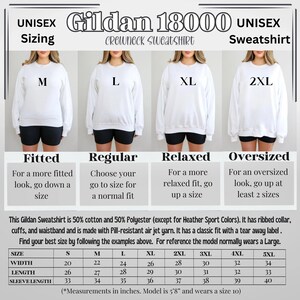 May include: A size chart for Gildan 18000 crewneck sweatshirts. The chart shows the width, length, and sleeve length in inches for sizes S through 5XL. The chart also includes descriptions of the fit for each size: fitted, regular, relaxed, and oversized.