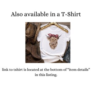 May include: White t-shirt featuring a Highland cow graphic with a pink bow. The cow has brown fur and is wearing a pink bow. The text "Also available in a T-Shirt" is at the top of the image.