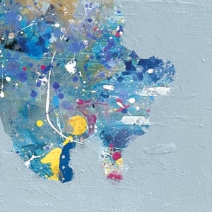 Pu&ograve; includere: Dipinto astratto con un motivo a spruzzo blu, giallo e bianco su uno sfondo grigio chiaro.