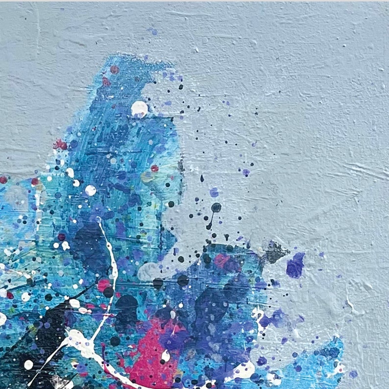 Pu&ograve; includere: Dipinto astratto con schizzi di vernice blu, bianca, nera e rosa su uno sfondo grigio chiaro.