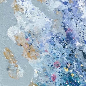 Pu&ograve; includere: Dipinto astratto con sfondo grigio e schizzi di vernice blu, bianca e dorata.