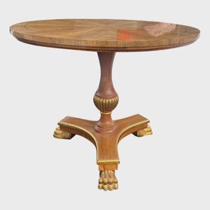 May include: A round wooden side table with a decorative pedestal base. The tabletop features a starburst pattern. The pedestal is brown with gold accents. The table stands approximately 28 inches tall.