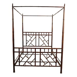 May include: A dark brown four-poster bed with a geometric design on the headboard and footboard. The bed frame is made of bamboo-style material, with vertical posts and horizontal rails forming the structure. The bed has a canopy frame.