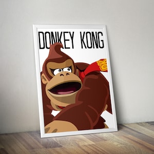 May include: A white framed print featuring a cartoon illustration of Donkey Kong, a brown gorilla with a red and yellow bandana, against a white background. The text "Donkey Kong" is printed in black at the top of the image.