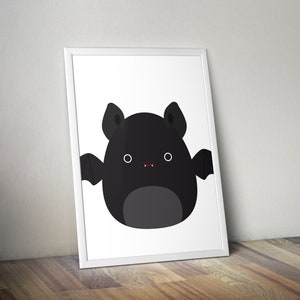 Könnte beinhalten: Ein gerahmter Druck mit einer Cartoon-Fledermaus-Illustration. Die Fledermaus ist schwarz mit großen Ohren, kleinen Flügeln und einem grauen Bauch. Sie hat weiße Augen und einen kleinen roten Mund. Der Druck ist in einem weißen Rahmen.