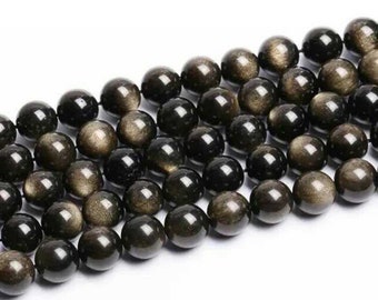 May include: A strand of black gemstone beads with gold flecks. The beads are round and smooth, and they are strung on a clear thread.