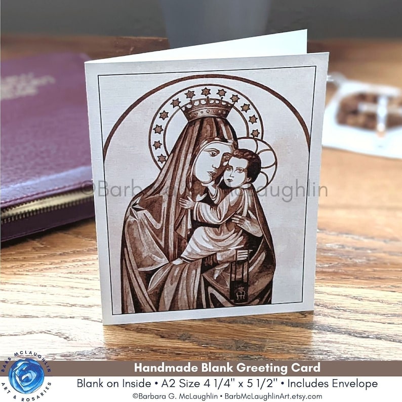 Puede incluir: Tarjeta de felicitaci&oacute;n en blanco hecha a mano con una ilustraci&oacute;n en tonos sepia de Mar&iacute;a con el ni&ntilde;o Jes&uacute;s, con halo y corona. La tarjeta mide 10,8 cm x 14 cm e incluye un sobre. La tarjeta est&aacute; en blanco por dentro.