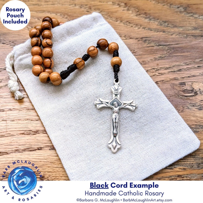 This five decade rosary includes a muslin rosary pouch (approximately 3 inches by 4 inches). Such a rustic and durable rosary to keep for yourself or give as a gift! A black cord rosary is displayed partly coming out of the muslin rosary bag.
