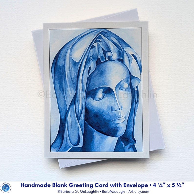 Handmade blank greeting card with art print of the Blessed Virgin Mary in blue ink, inspired by Michelangelo's Pieta.  Displayed with a white envelope behind the folded card on piece of white water color paper.