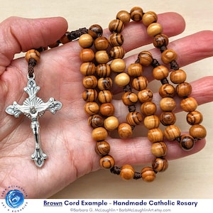 I inspect each bead when stringing rosaries by hand. Brown cord rosary is pictured.