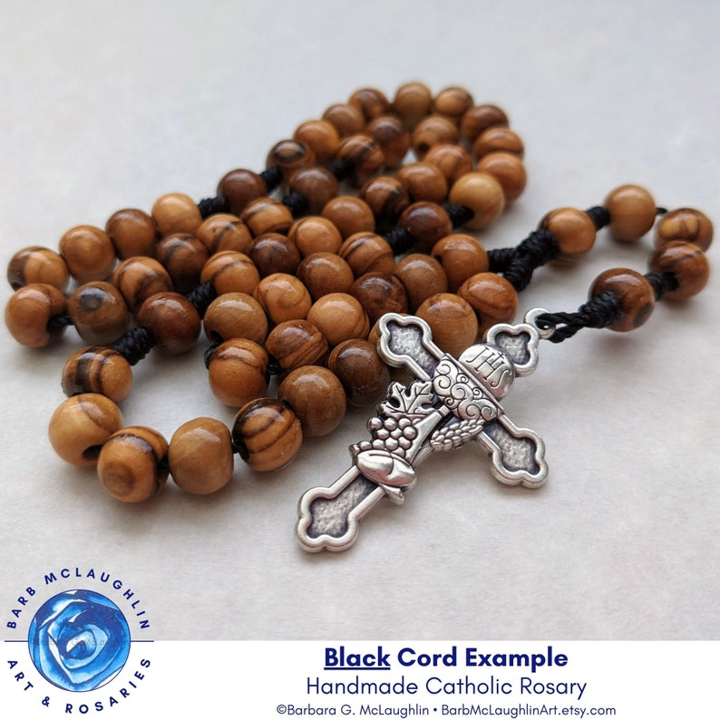 Handmade First Communion rosary with movable 7mm authentic Holy Land olive wood beads, Italian-metal cross, and black nylon cord. The metal cross has smooth corners and feels comfortable in the palm of the hand.