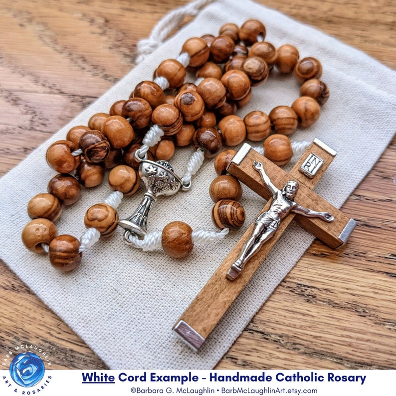 Handmade First Communion rosary with movable 7mm Holy Land olive olive wood beads, metal chalice centerpiece, Italian-made crucifix, and white nylon cord. Lovely five decade rosary to remember 1st Holy Communion for boys or girls.