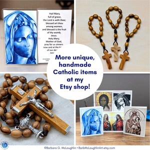 A collage of four of my handmade Catholic items - Blue Virgin Mary holy card, olive wood rosary ring set, First Communion rosary with chalice centerpiece, and assortment of my handmade Catholic art cards. The text in the image reads "More unique, handmade Catholic items at my Etsy shop!"