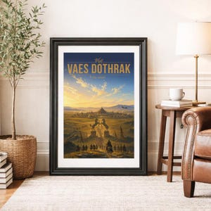 May include: A framed travel poster featuring a landscape illustration of a city with two large horse statues at the entrance. The text at the top reads Visit VAES DOTHRAK in gold lettering against a blue sky with a sunset over a vast grassy plain.
