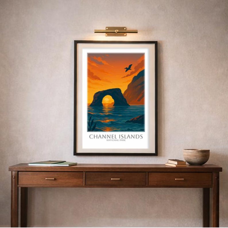May include: Framed art print featuring a scenic view of the Channel Islands National Park. The artwork depicts a rock archway over the ocean under a vibrant orange and blue sunset. The text "Channel Islands National Park" is at the bottom.