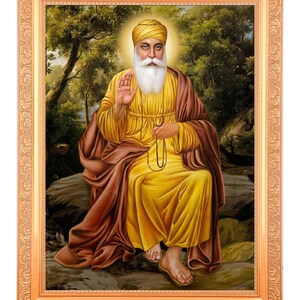 Può includere: Ritratto incorniciato di una figura religiosa, raffigurata con barba e turbante bianchi, che indossa abiti gialli e marroni. La figura è seduta su una roccia, con uno sfondo di foresta. La cornice è color oro.