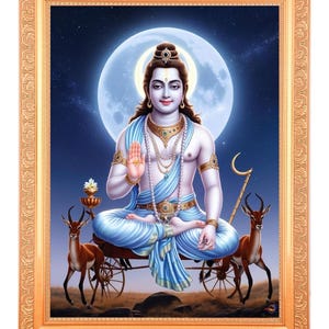 Könnte beinhalten: Gerahmtes Kunstwerk, das eine Gottheit in meditativer Pose vor dem Hintergrund eines Vollmonds und einer sternenklaren Nacht darstellt. Die Figur ist mit Schmuck geschmückt und in blaues Tuch gehüllt, sitzend auf einem von Hirschen gezogenen Wagen.