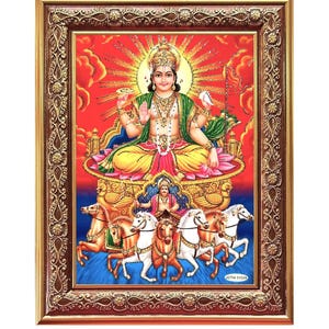 Könnte beinhalten: Ein gerahmter religiöser Druck, der die hinduistische Gottheit Surya, den Sonnengott, darstellt, der einen von sieben weißen Pferden gezogenen Wagen fährt. Er sitzt auf einem Lotusthron, geschmückt mit einer goldenen Krone und Schmuck, und ist von einem strahlenden Heiligenschein umgeben. Der Druck ist vor einem roten und orangefarbenen Hintergrund mit Wolken und einem goldenen Rahmen platziert.